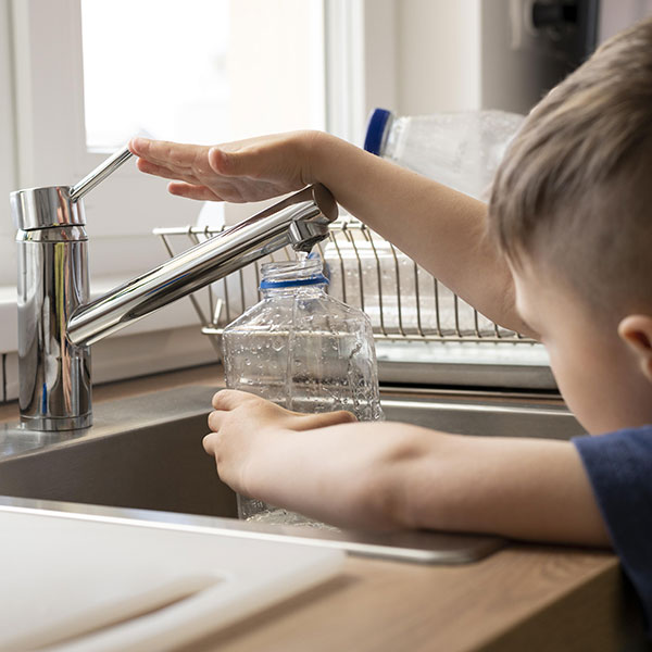 kid getting water from kitchen sink